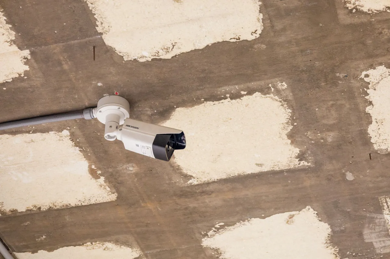 Bullet camera with flexible conduit fixed to a concrete ceiling