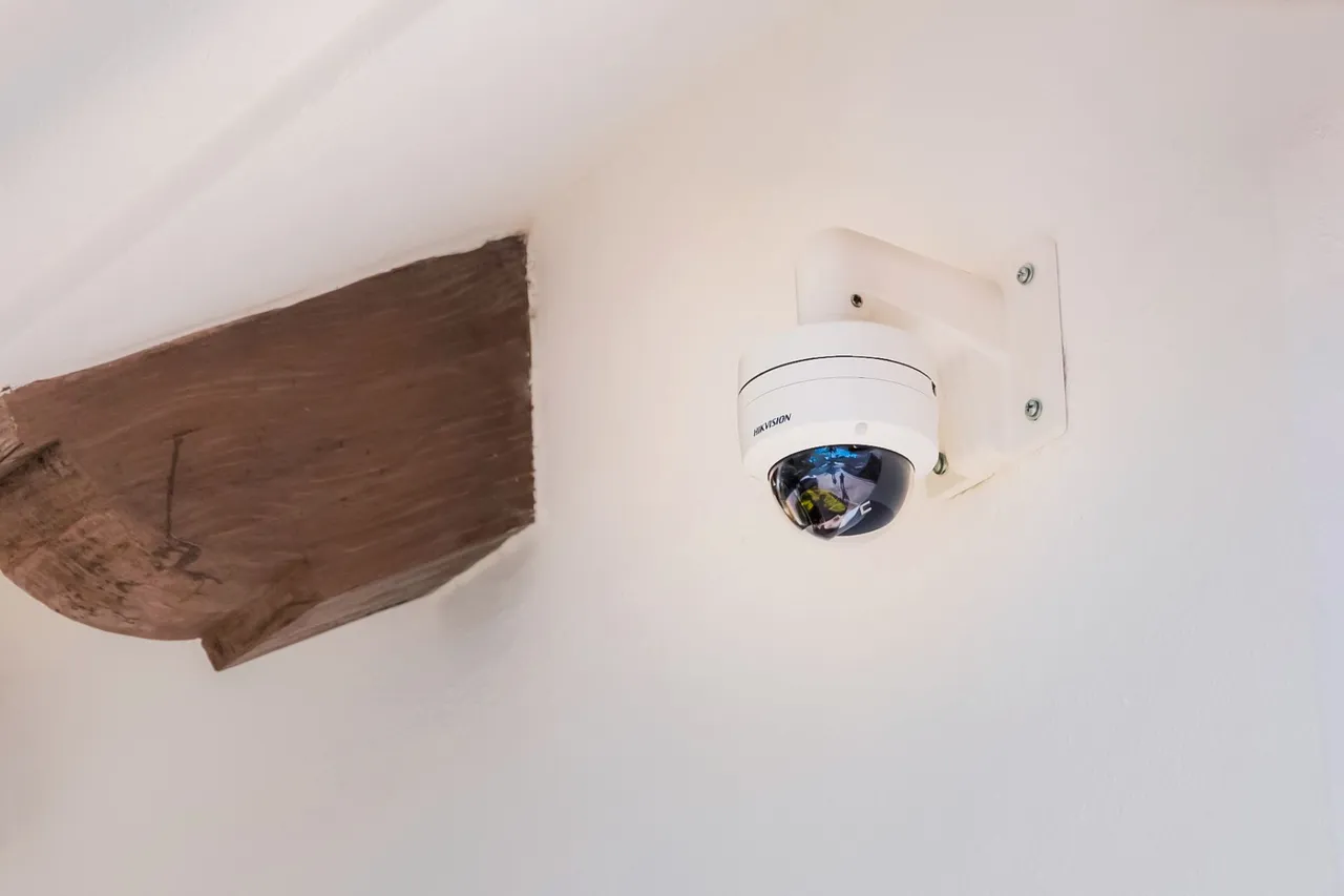 Wall-mounted dome camera next to a wooden beam