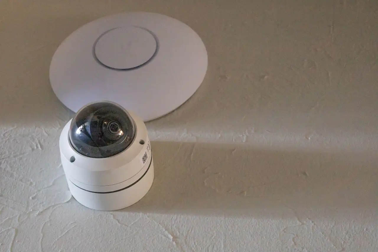 WiFi access point and dome camera installed together on a textured wall