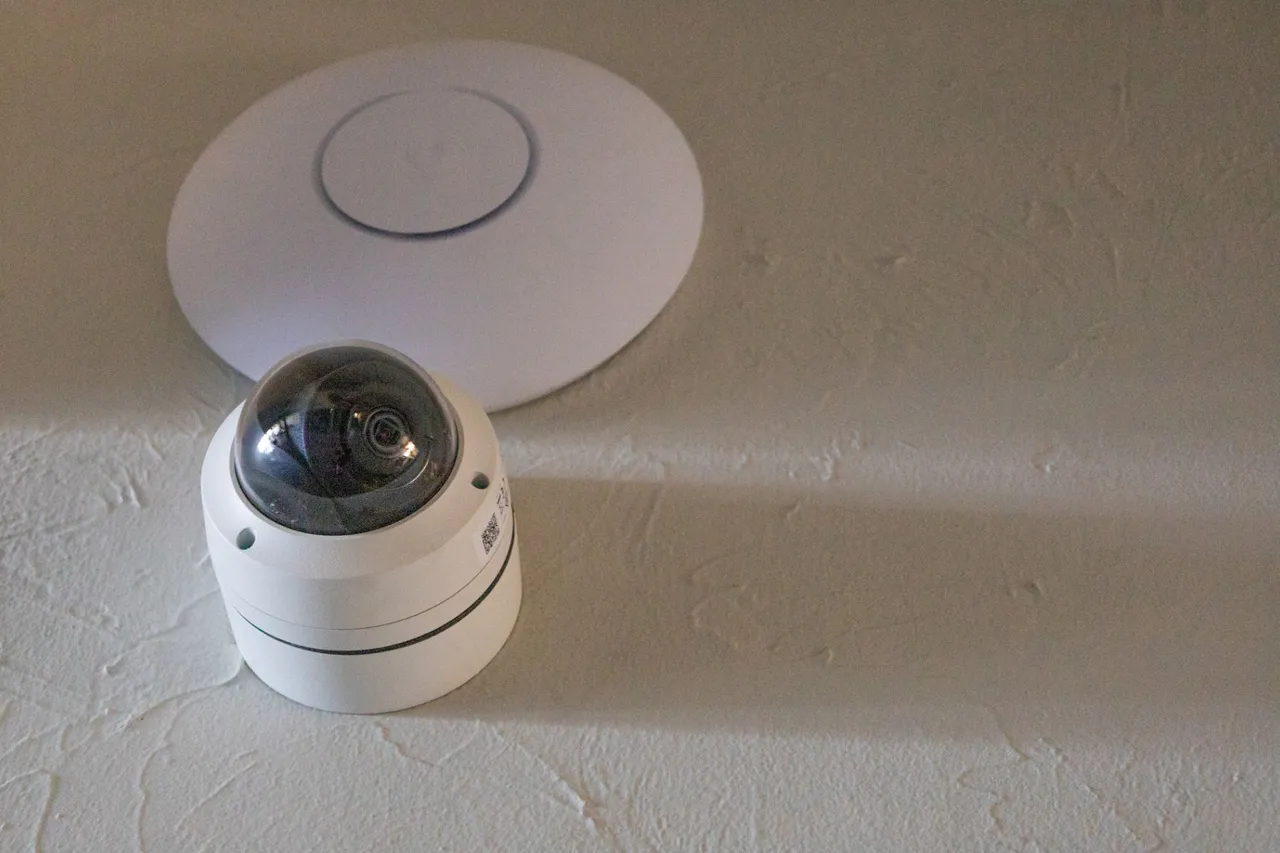 WiFi access point and dome camera installed together on a textured wall