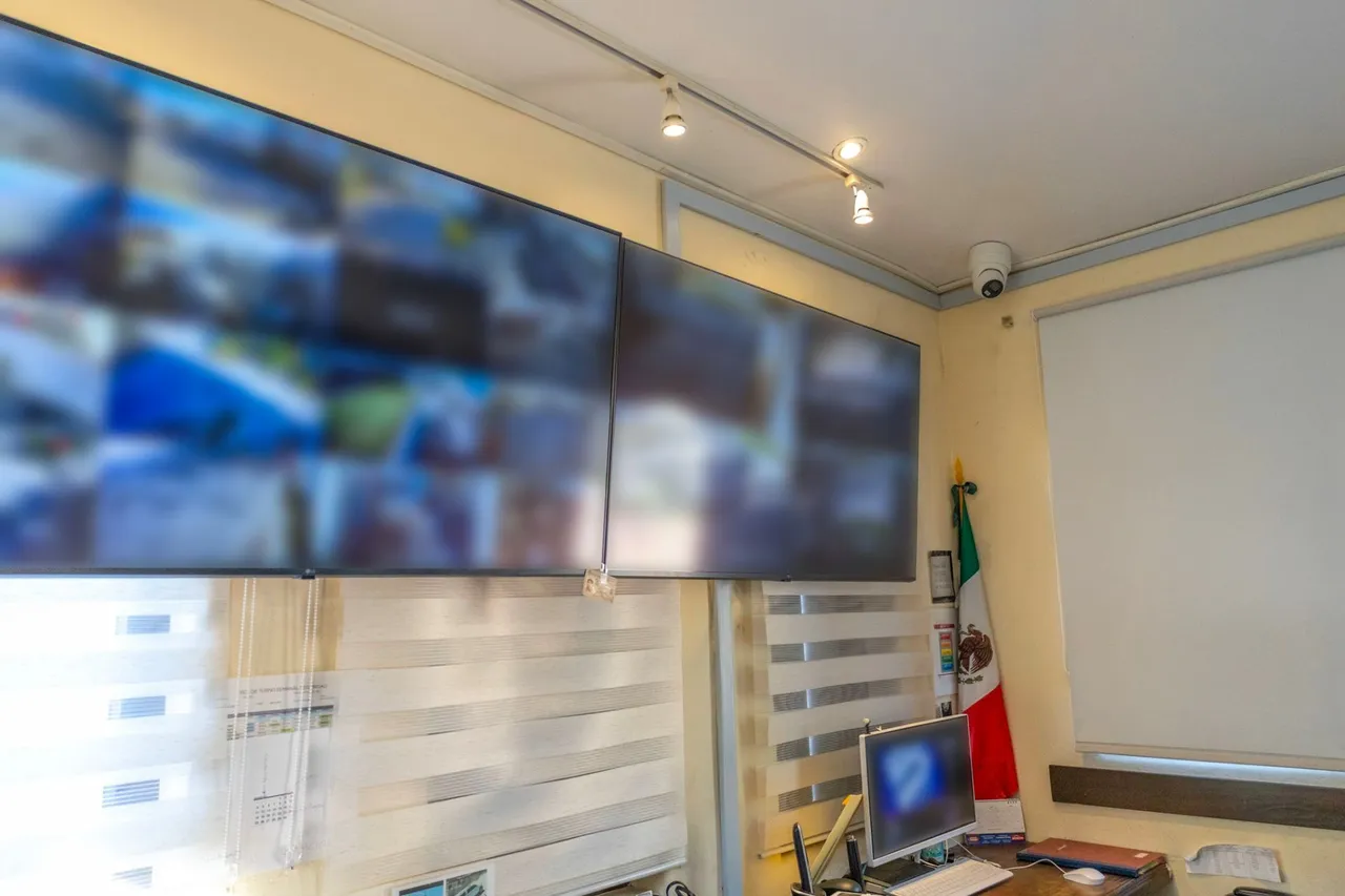 Monitoring room with two large screens and a dome camera on the ceiling