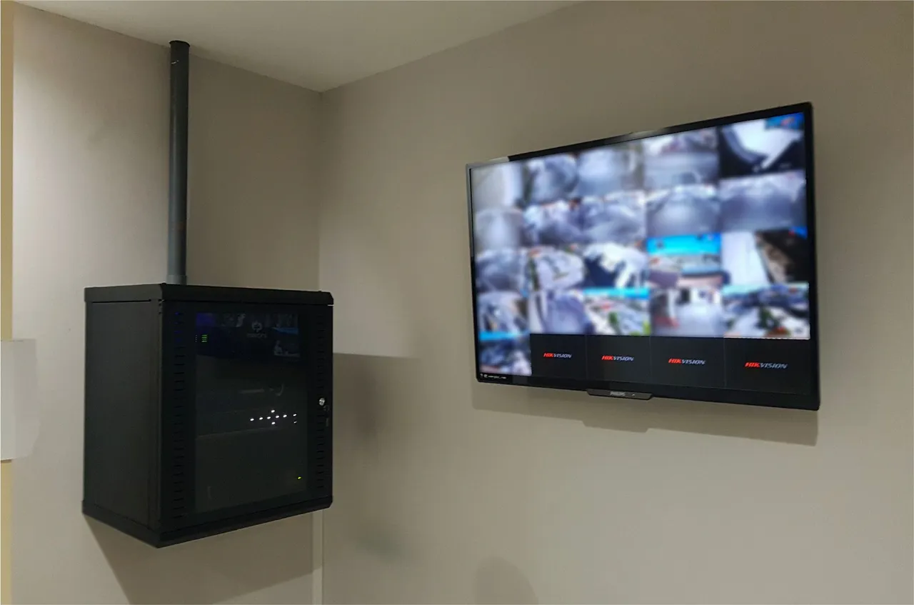 Network cabinet and a TV showing a camera grid, mounted on the wall