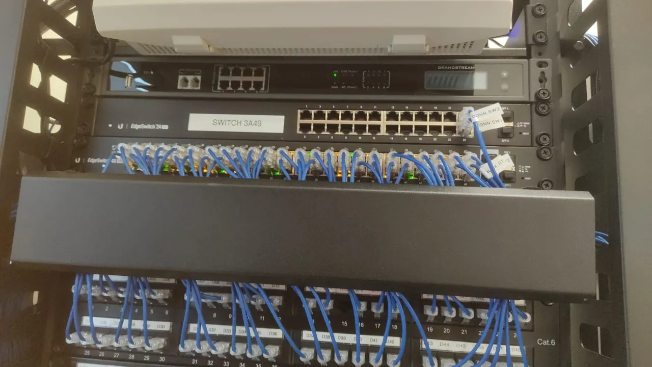 Rack with switches, a Cat.6 patch panel and neatly arranged blue patch cables