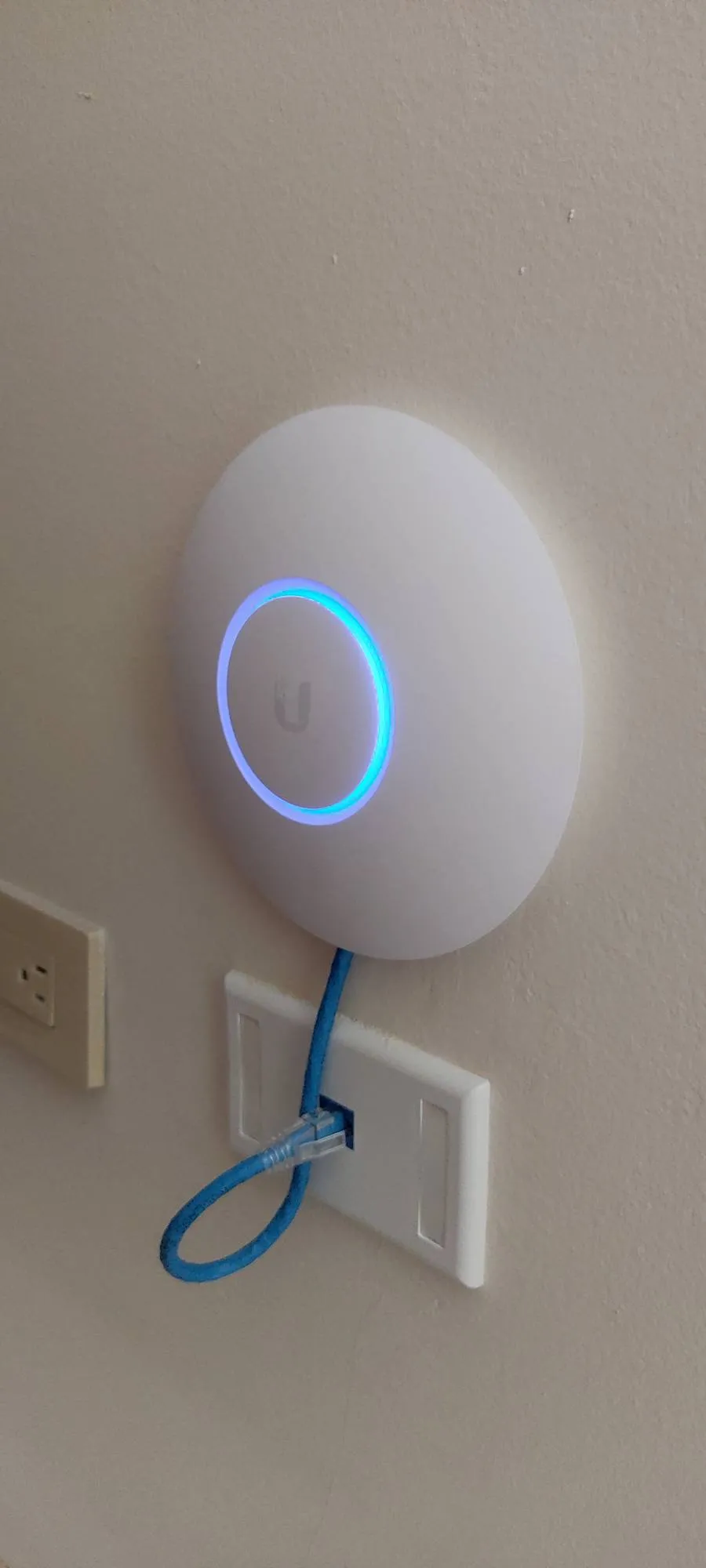 WiFi access point with a blue light ring, connected with a network cable