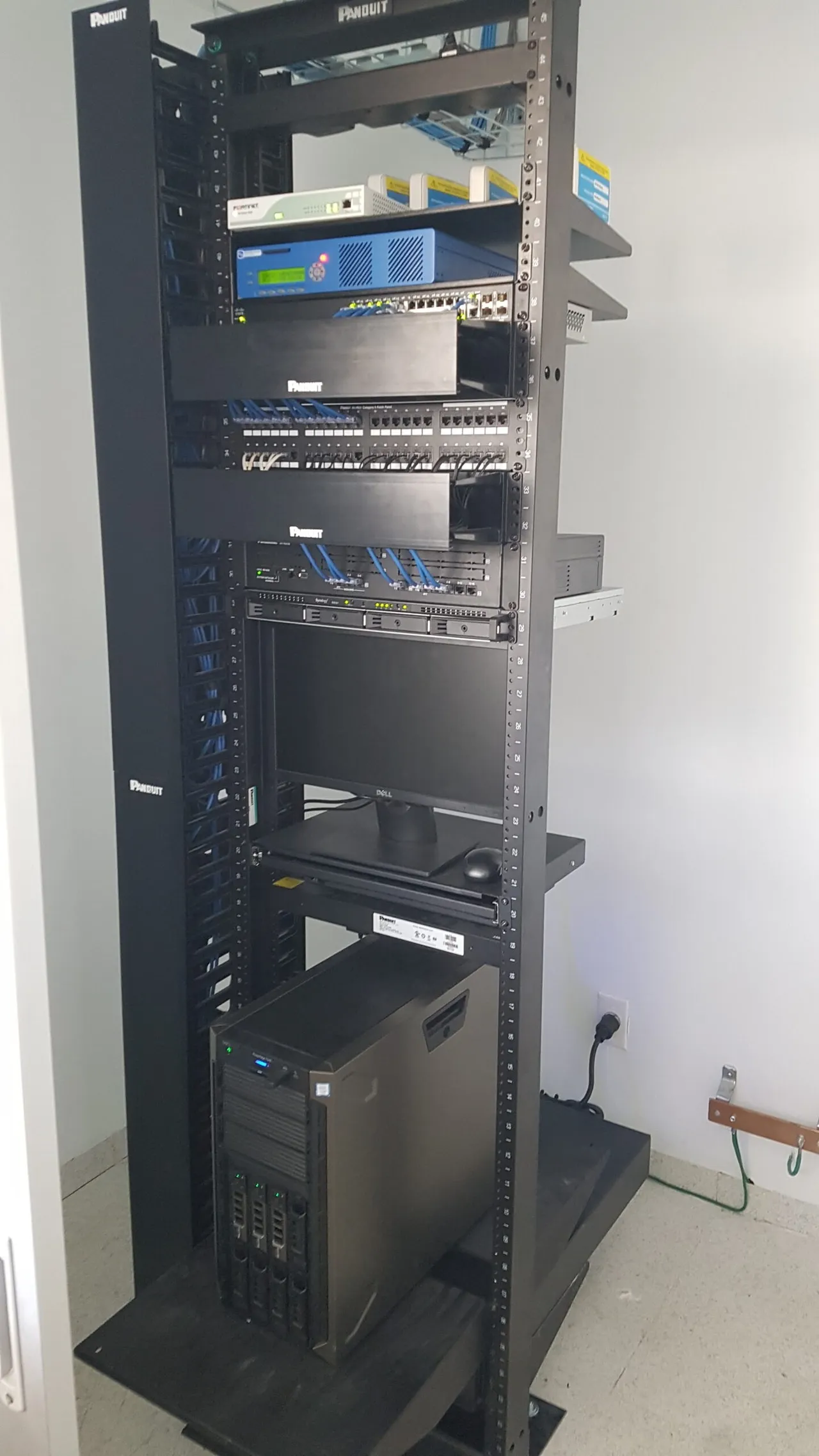 Open-frame rack with a patch panel, network equipment and a tower server