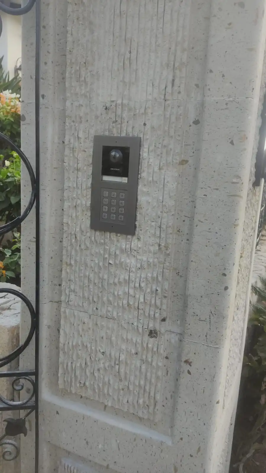 Outdoor video intercom with keypad on a stone pillar